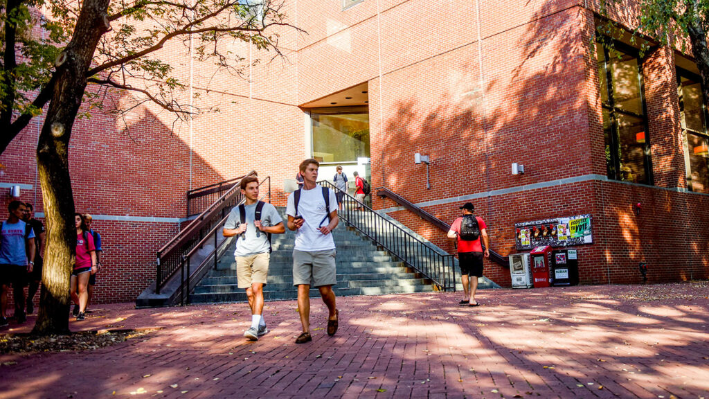 students walking in front of brick building
