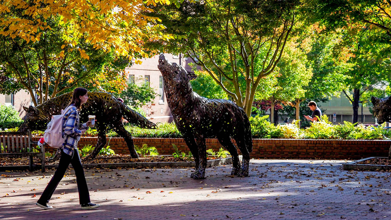 Fall foliage frames the copper wolves at Wolf Plaza.
